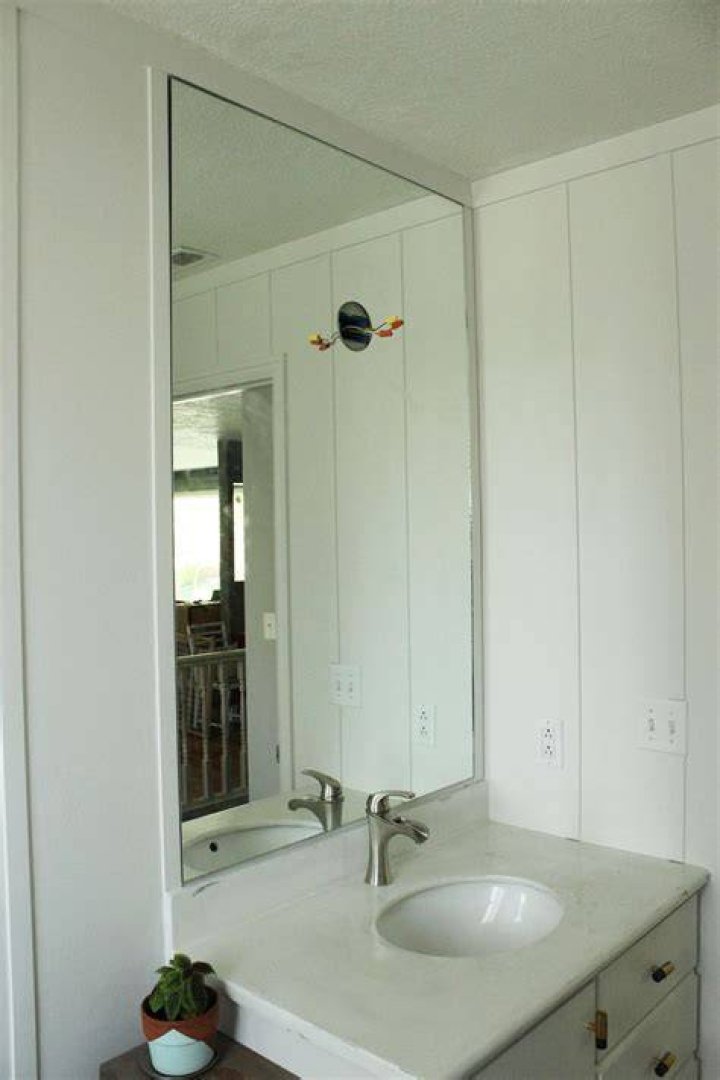 How do you install a frameless mirror in a bathroom?